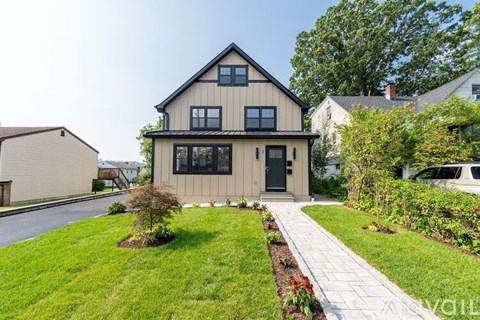A house with a grey roof and a white fence.