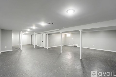 A spacious room with a concrete floor and white walls.