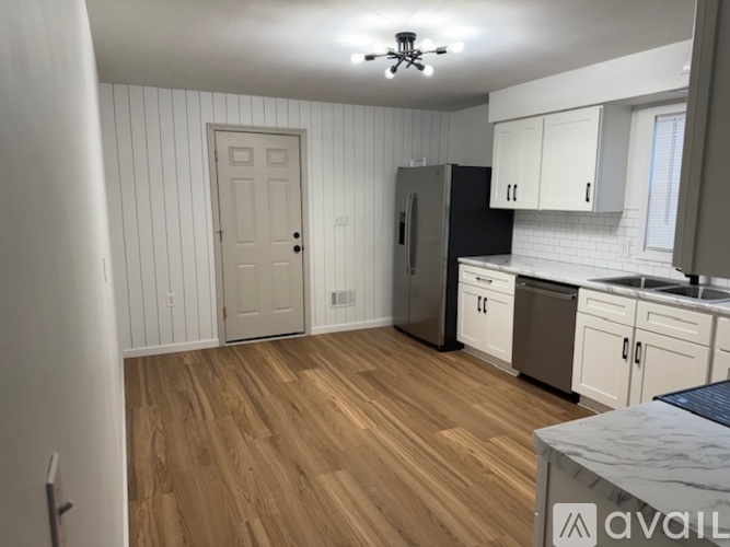 A kitchen with wooden floors and white walls.