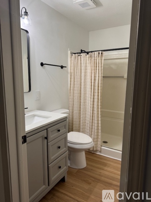 A bathroom with a toilet, sink, and shower.