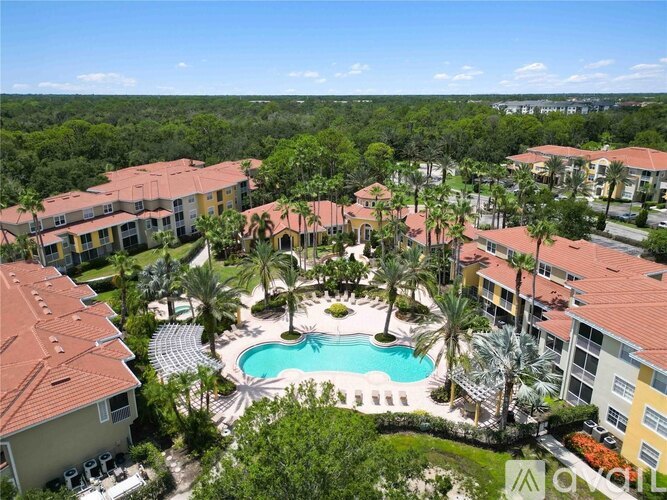 A pool surrounded by palm trees and buildings.