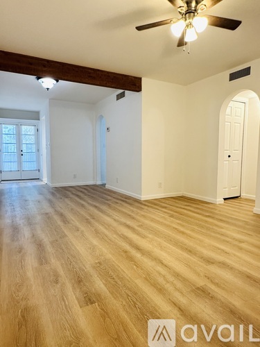 A room with wooden flooring and a ceiling fan.
