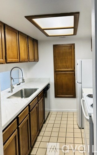 A kitchen with wooden cabinets and a white fridge.