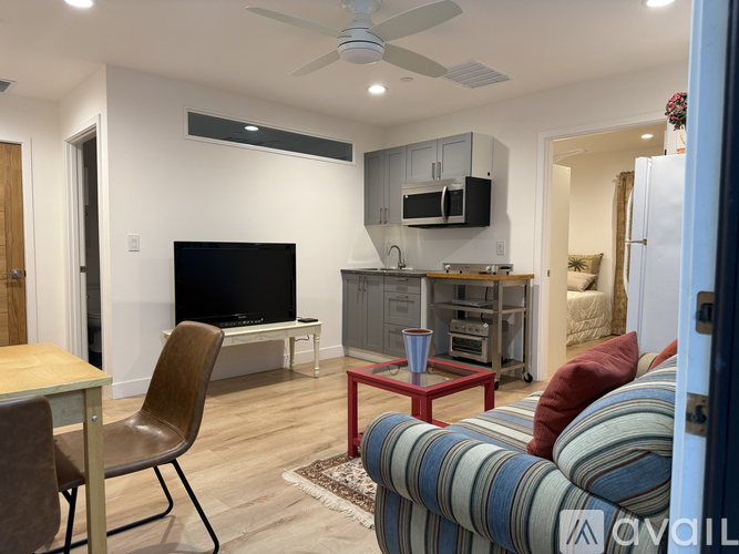 A living room with a television, a chair, and a couch.