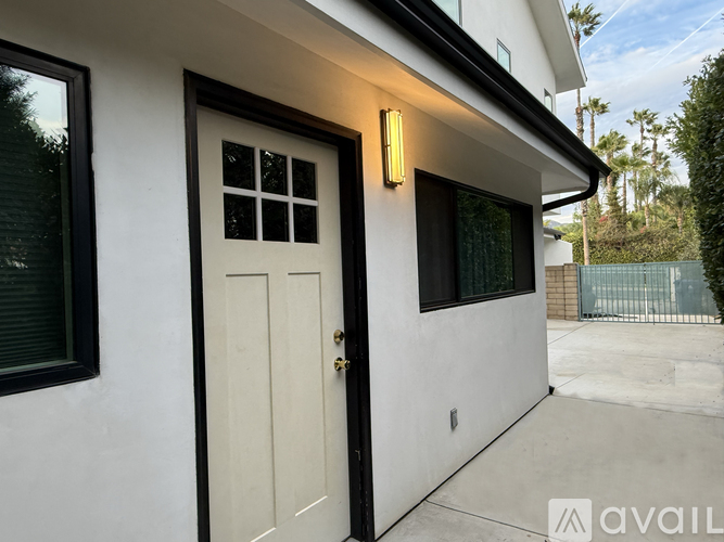 A modern house with a white door and a black window.