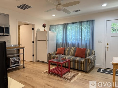 A living room with a striped couch and a red coffee table.