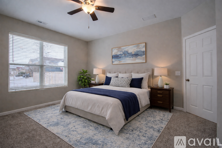 A bedroom with a large bed and a ceiling fan.