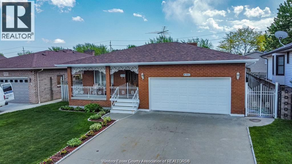 A house with a garage and a sign that says REALTOR.