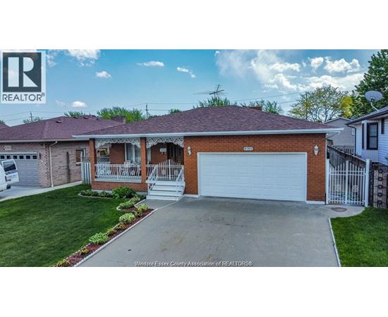 A house with a garage and a sign that says REALTOR.