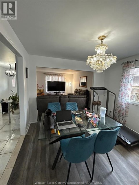 A living room with a glass table and blue chairs.