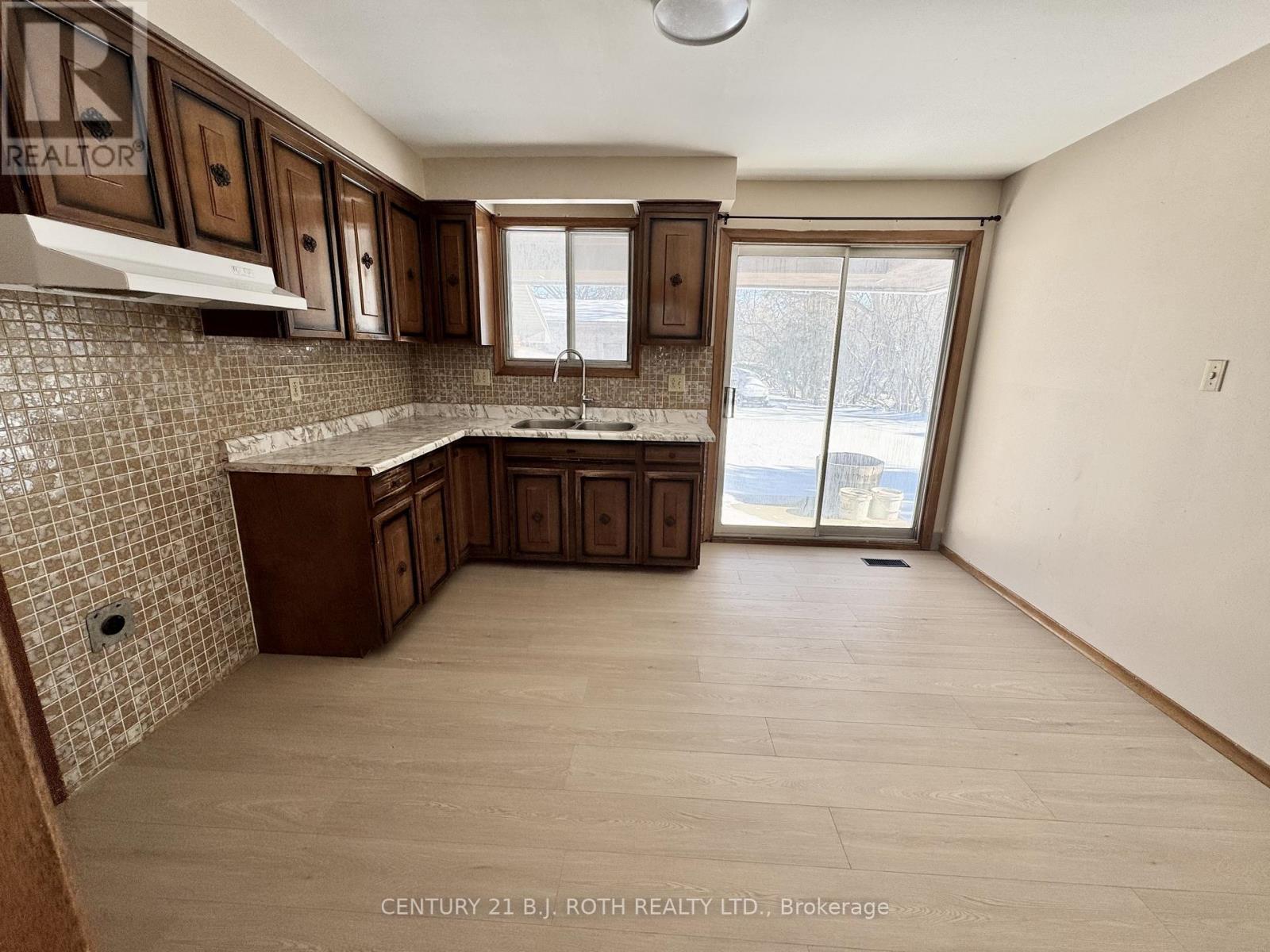 A kitchen with brown cabinets and a tiled backsplash.