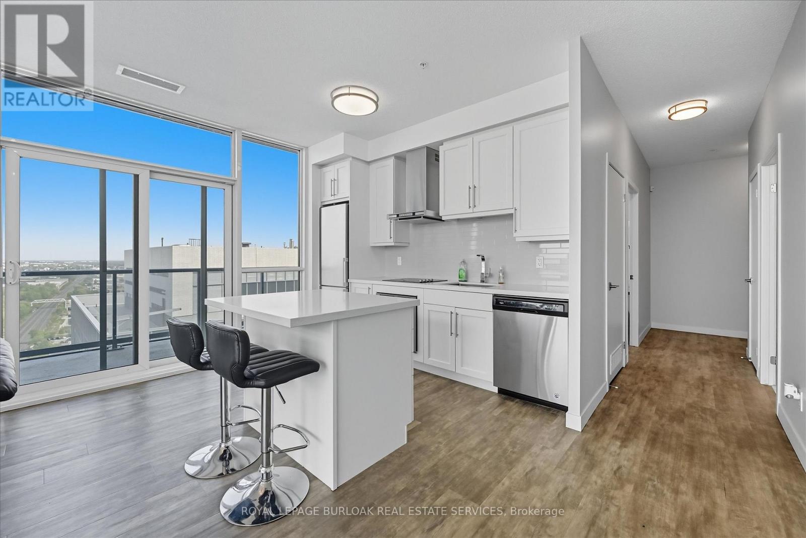 A well-lit kitchen with white cabinets and a bar area.