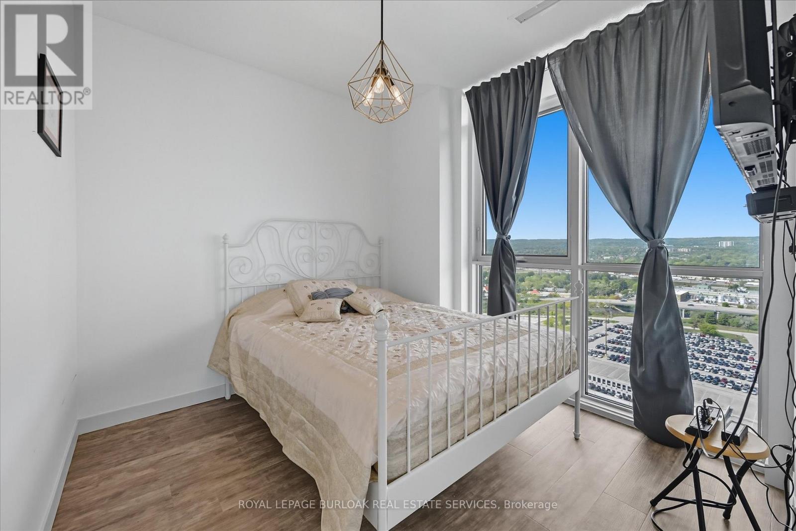 A bedroom with a large bed and a view of the city.