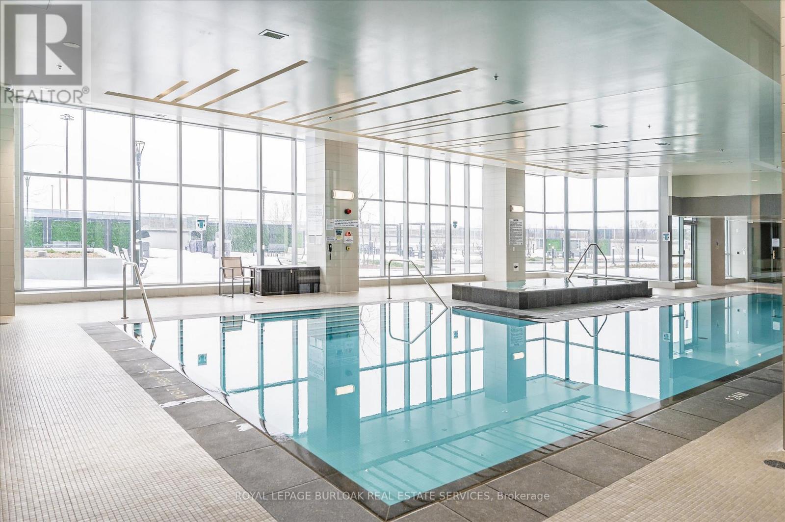 A large indoor swimming pool with a glass wall.
