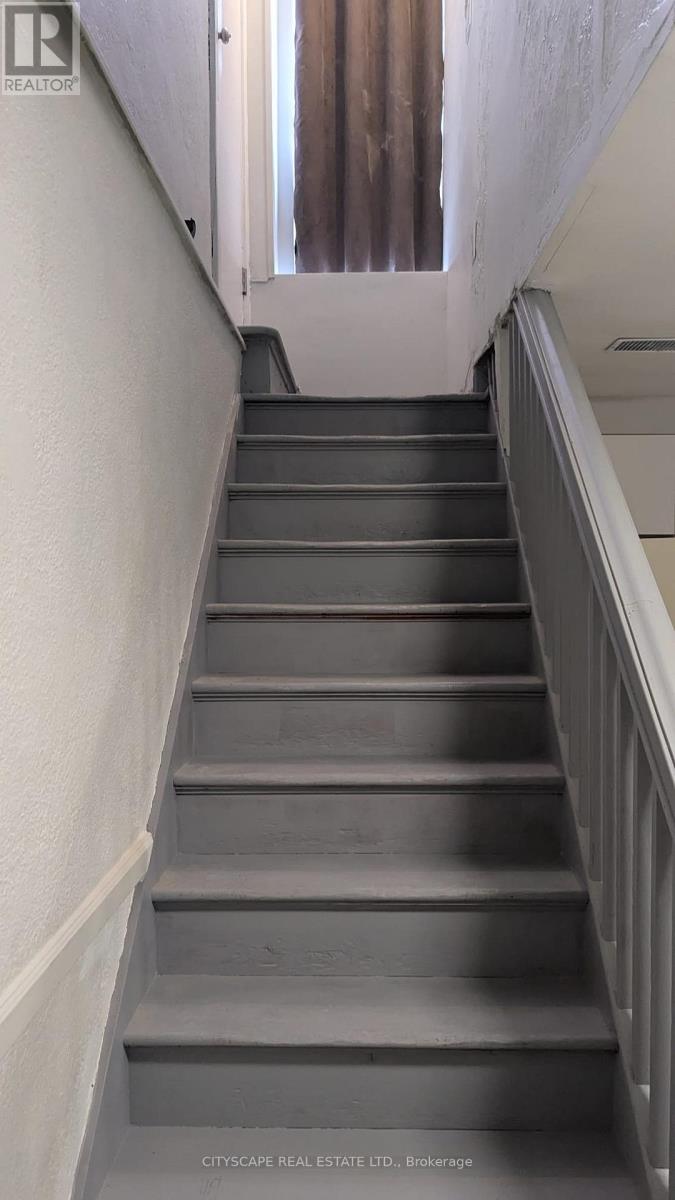 A flight of stairs with a metal railing on the right side.