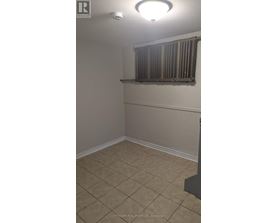 A room with beige walls and tiled flooring.