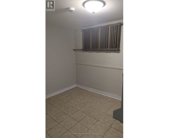 A room with beige walls and tiled flooring.