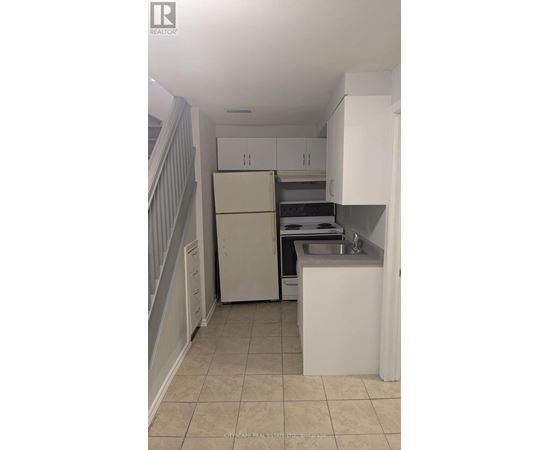 A kitchen with white cabinets and a white fridge.