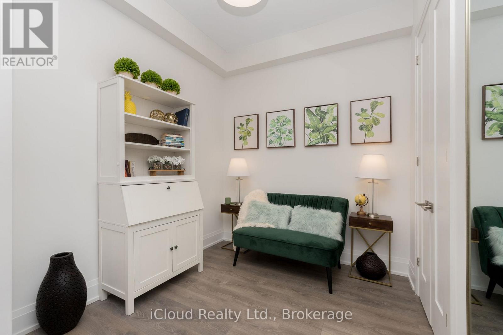 A white cabinet with shelves and a green couch in a room.