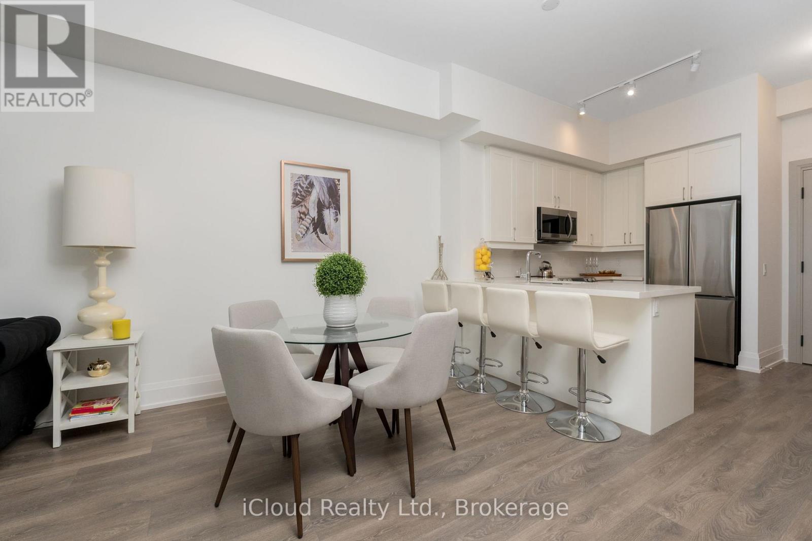 A modern kitchen with a dining table set up with four chairs.