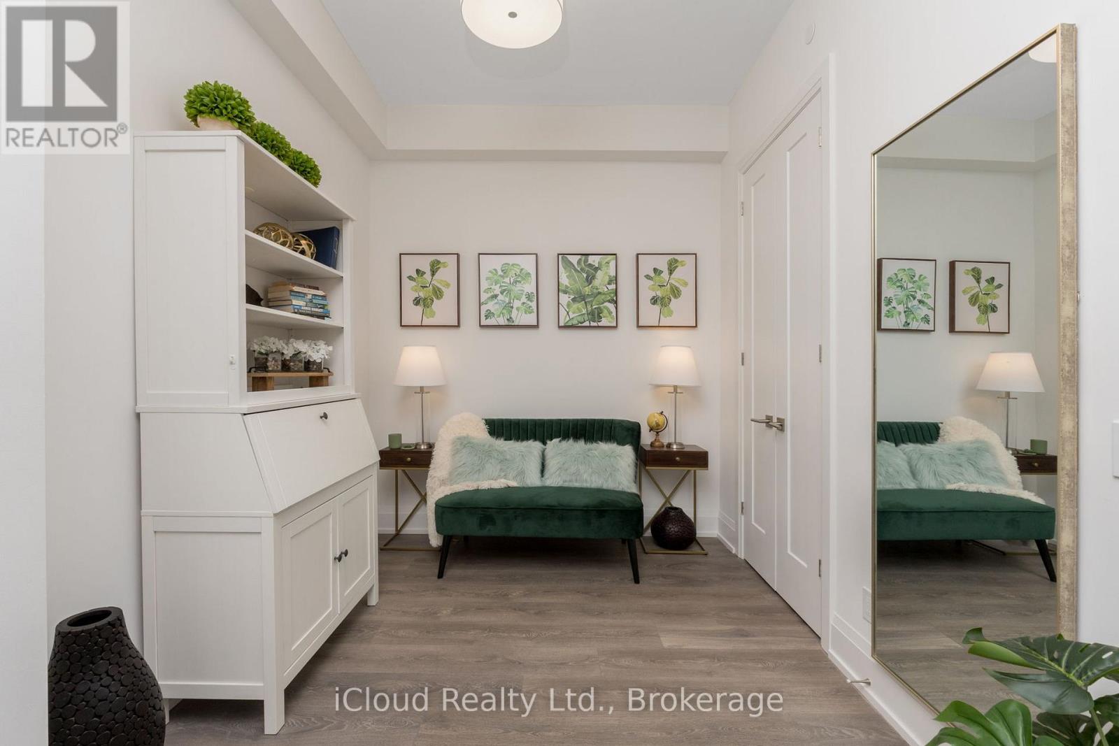 A bedroom with a bed, a couch, a cabinet, and a mirror.