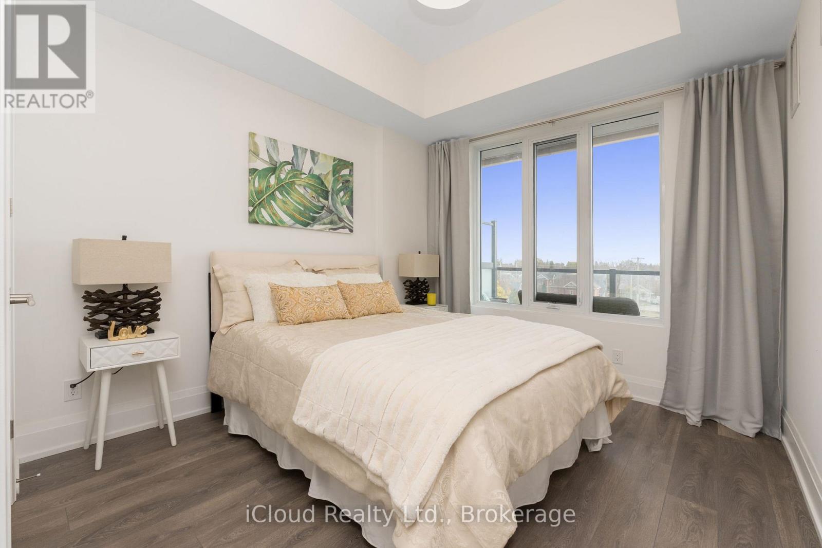 A bedroom with a large bed and a window overlooking the ocean.