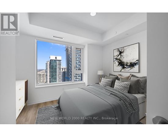 A bedroom with a large bed and a city view through the window.