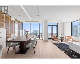 A modern dining room with a long table and chairs.