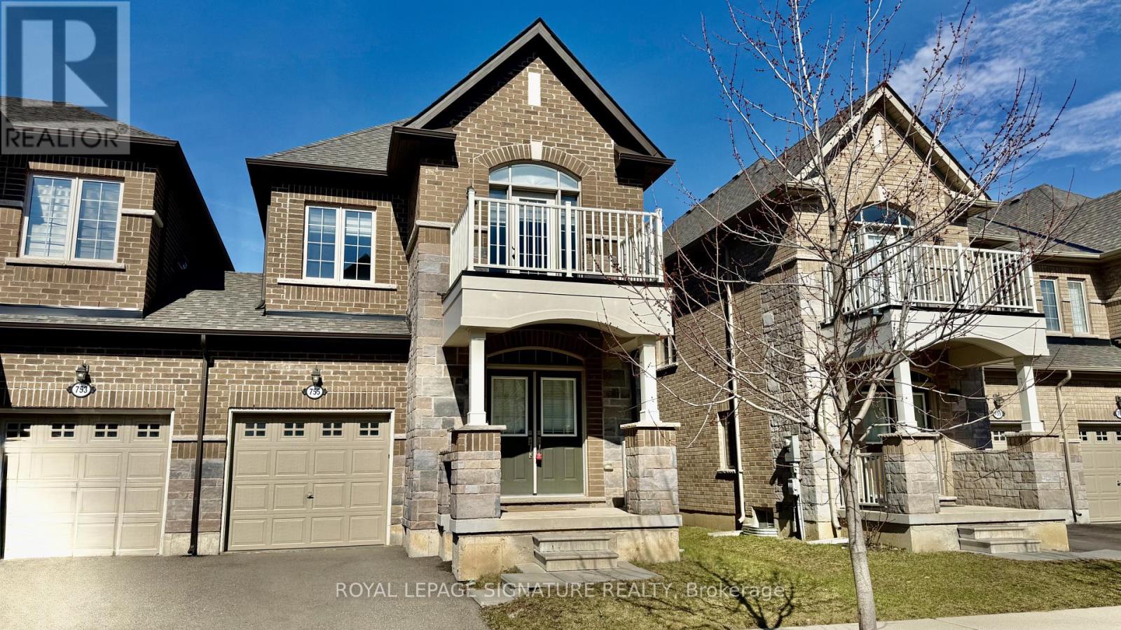 A large, two-story house with a balcony and a garage is for sale.