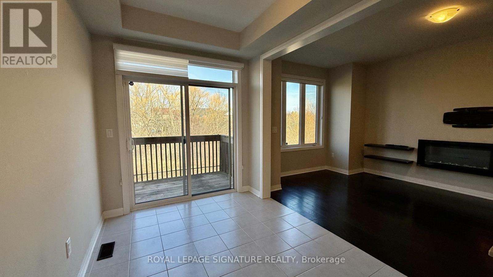 A spacious room with a sliding glass door leading to a balcony.