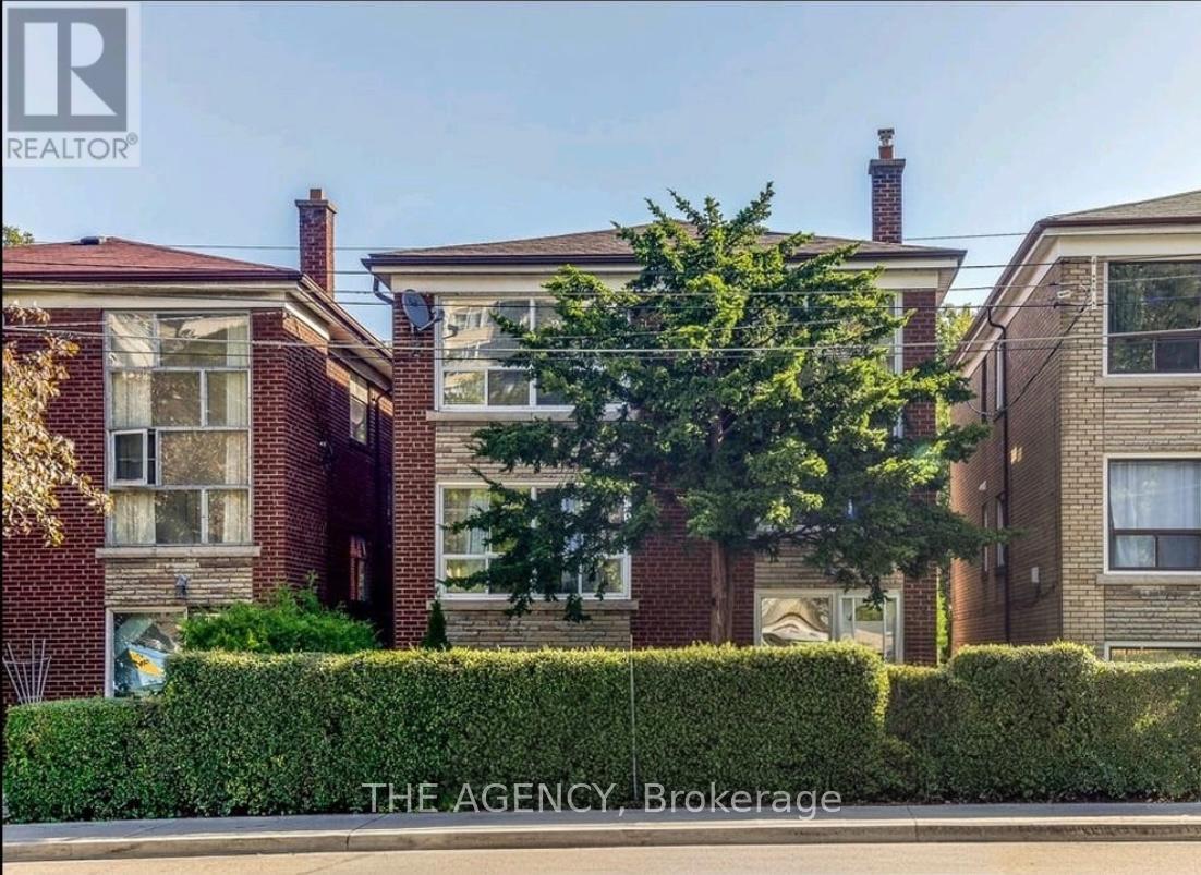 A row of houses with a sign that says "The Agency Brokerage".