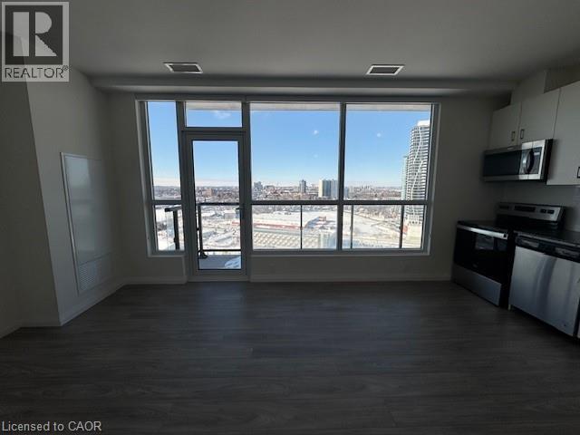 A spacious room with a view of the cityscape through large windows.