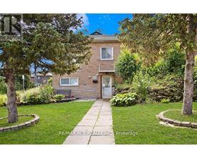 A house with a lawn and trees in front of it.