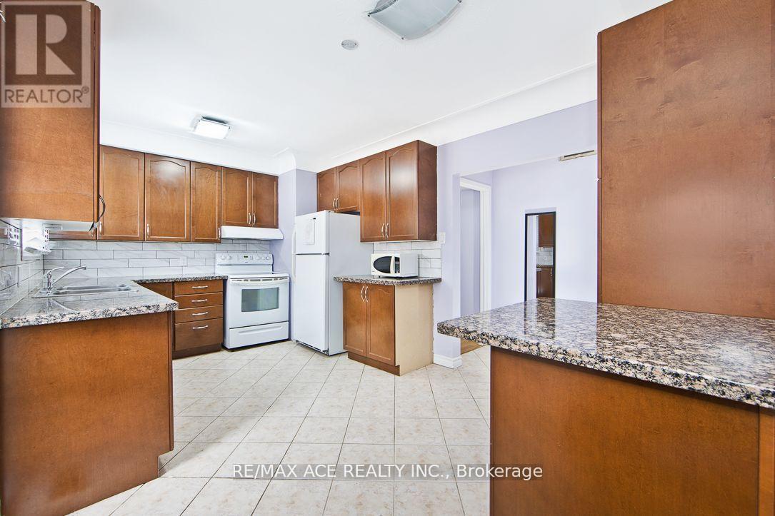 A kitchen with brown cabinets and a granite countertop.