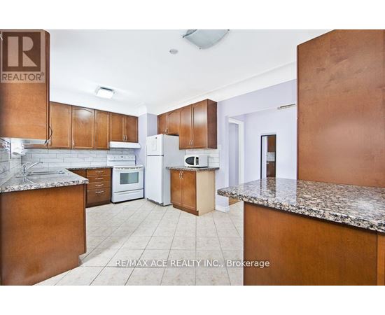 A kitchen with brown cabinets and a granite countertop.