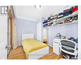 A bedroom with a bed, desk, and chair.
