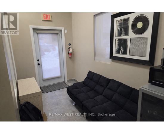 A brokerage office with a black couch and a framed record on the wall.