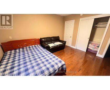 A bedroom with a bed and a chair.