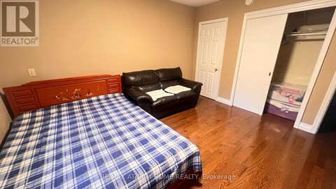 A bedroom with a bed and a chair.