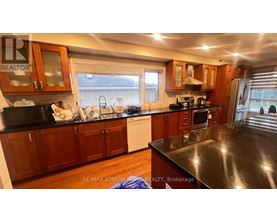 A kitchen with wooden cabinets and black countertops.