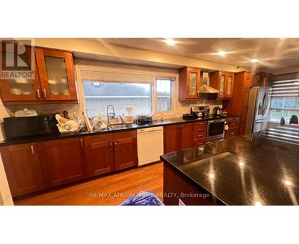 A kitchen with wooden cabinets and black countertops.