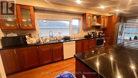 A kitchen with wooden cabinets and black countertops.