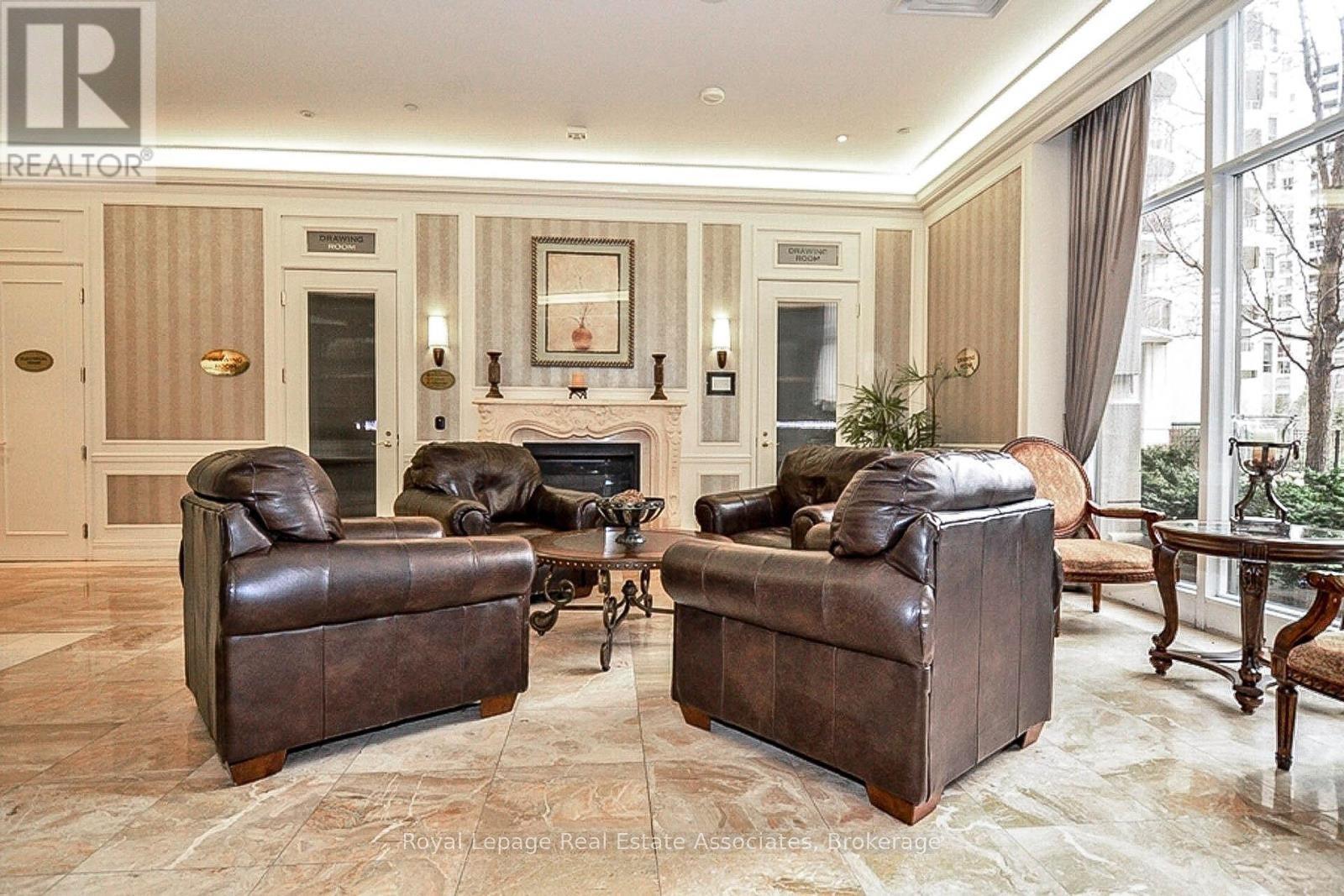 A living room with two brown leather sofas and a fireplace.