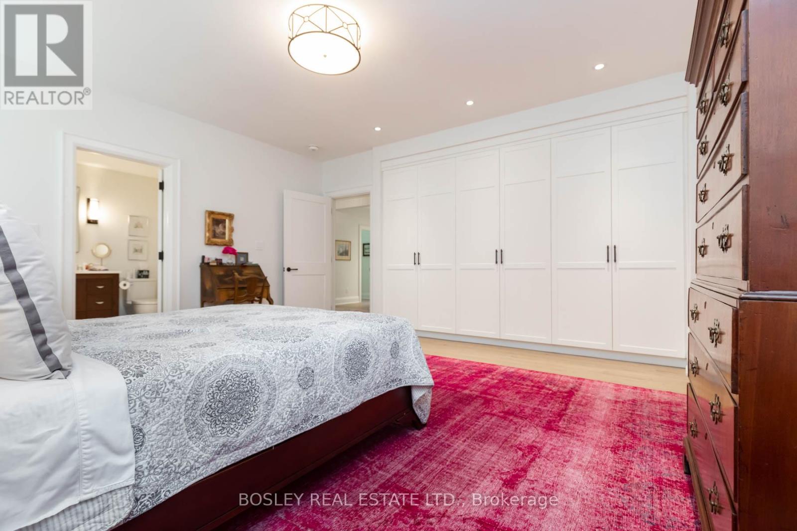 A bedroom with a large bed and a red carpet.