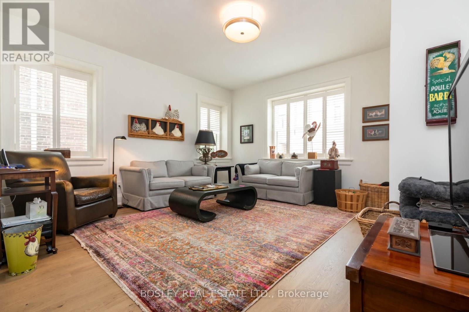 A living room with a rug on the floor and a couch in the background.