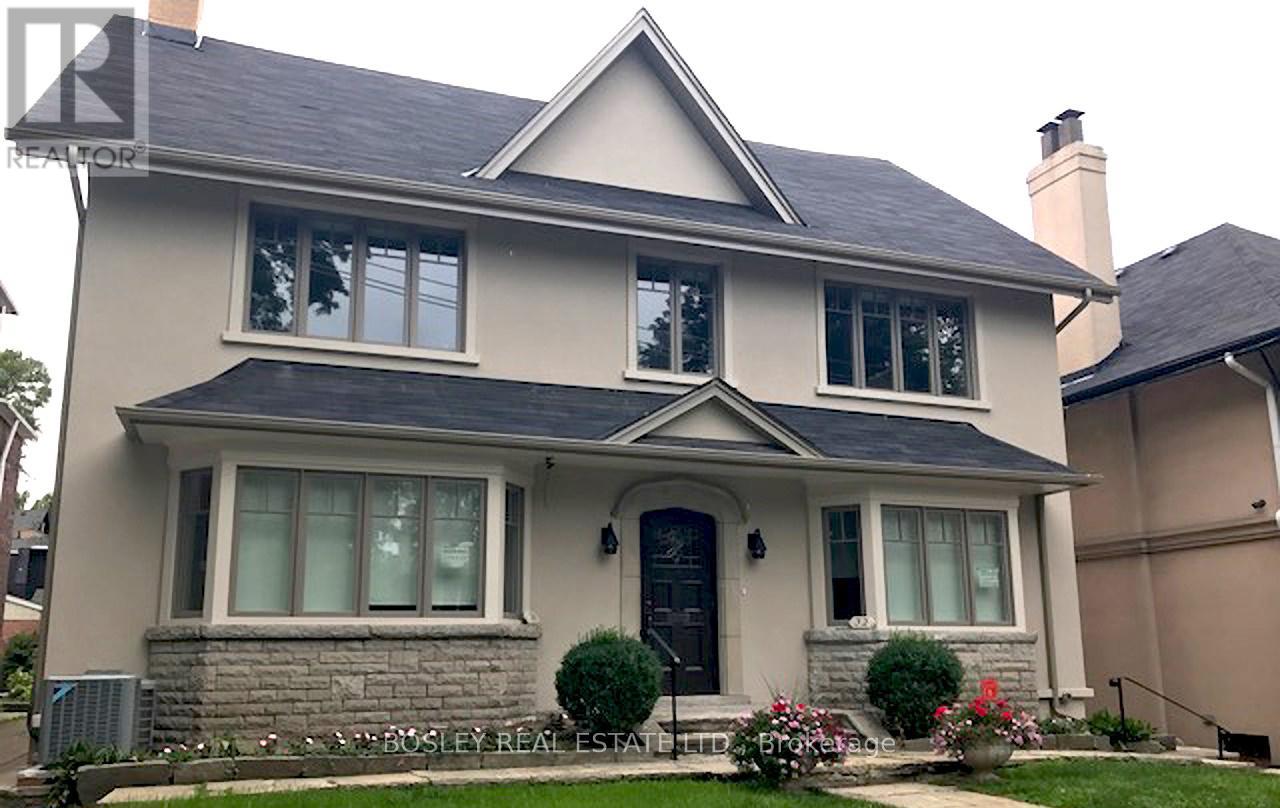 A house with a blue door and windows is for sale.