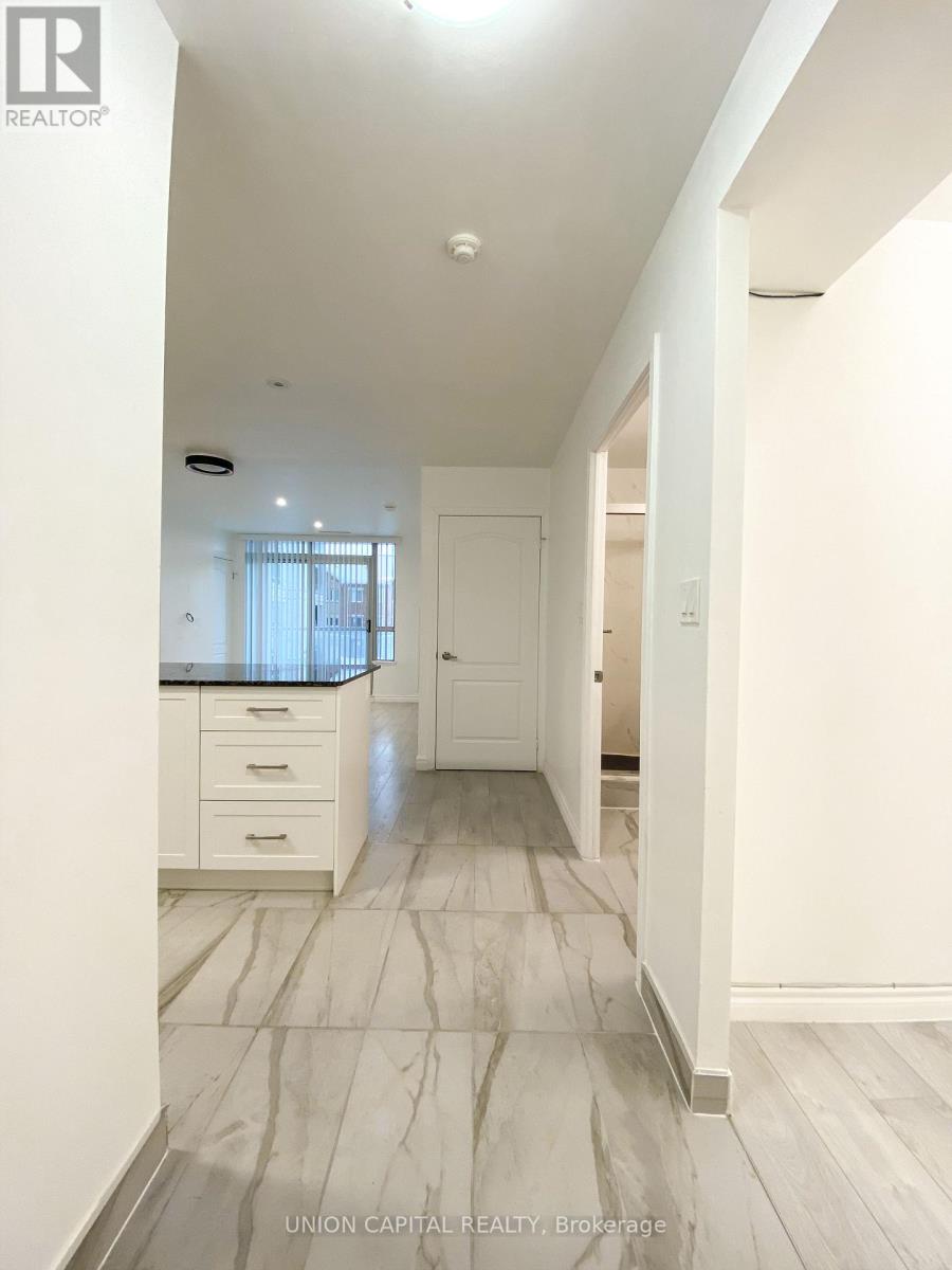 A spacious hallway with marble flooring and white walls.