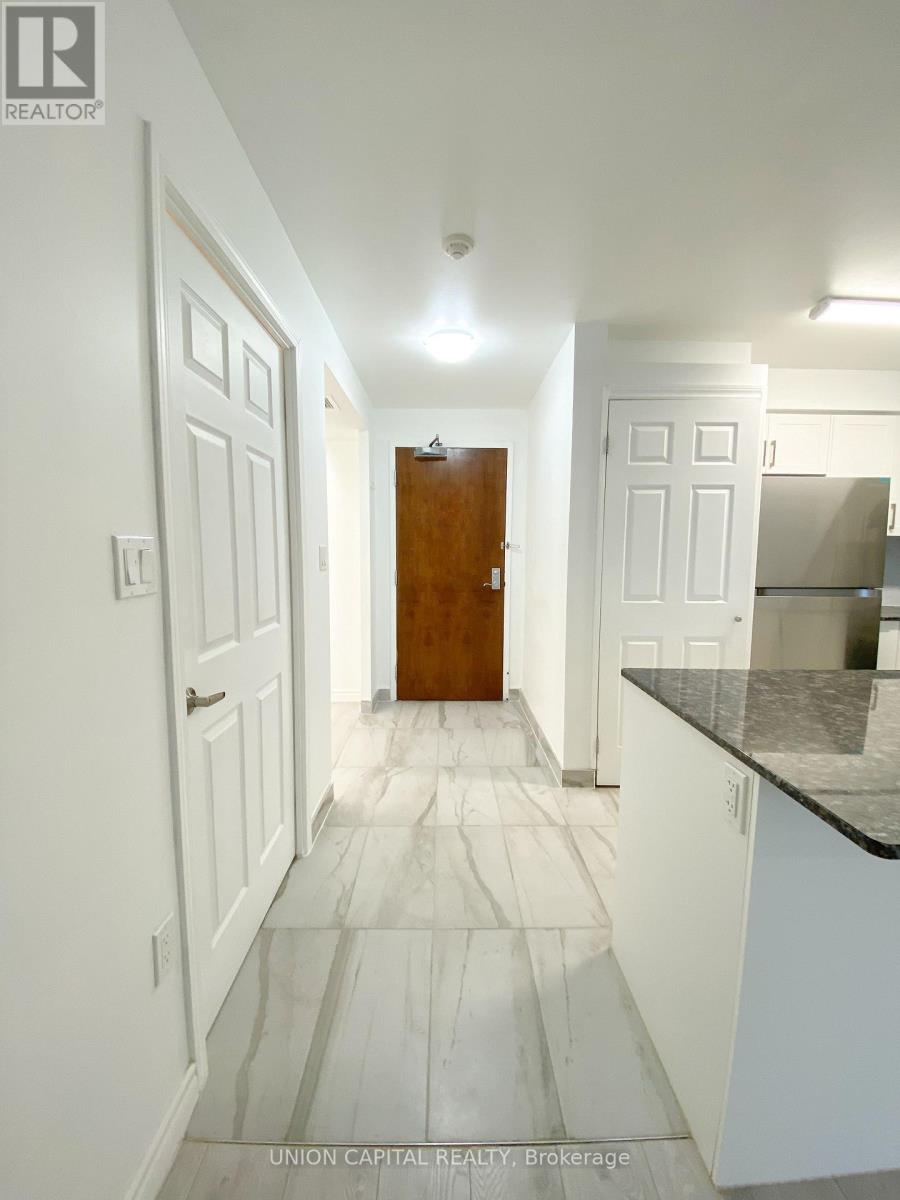 A hallway with a wooden door and white walls.