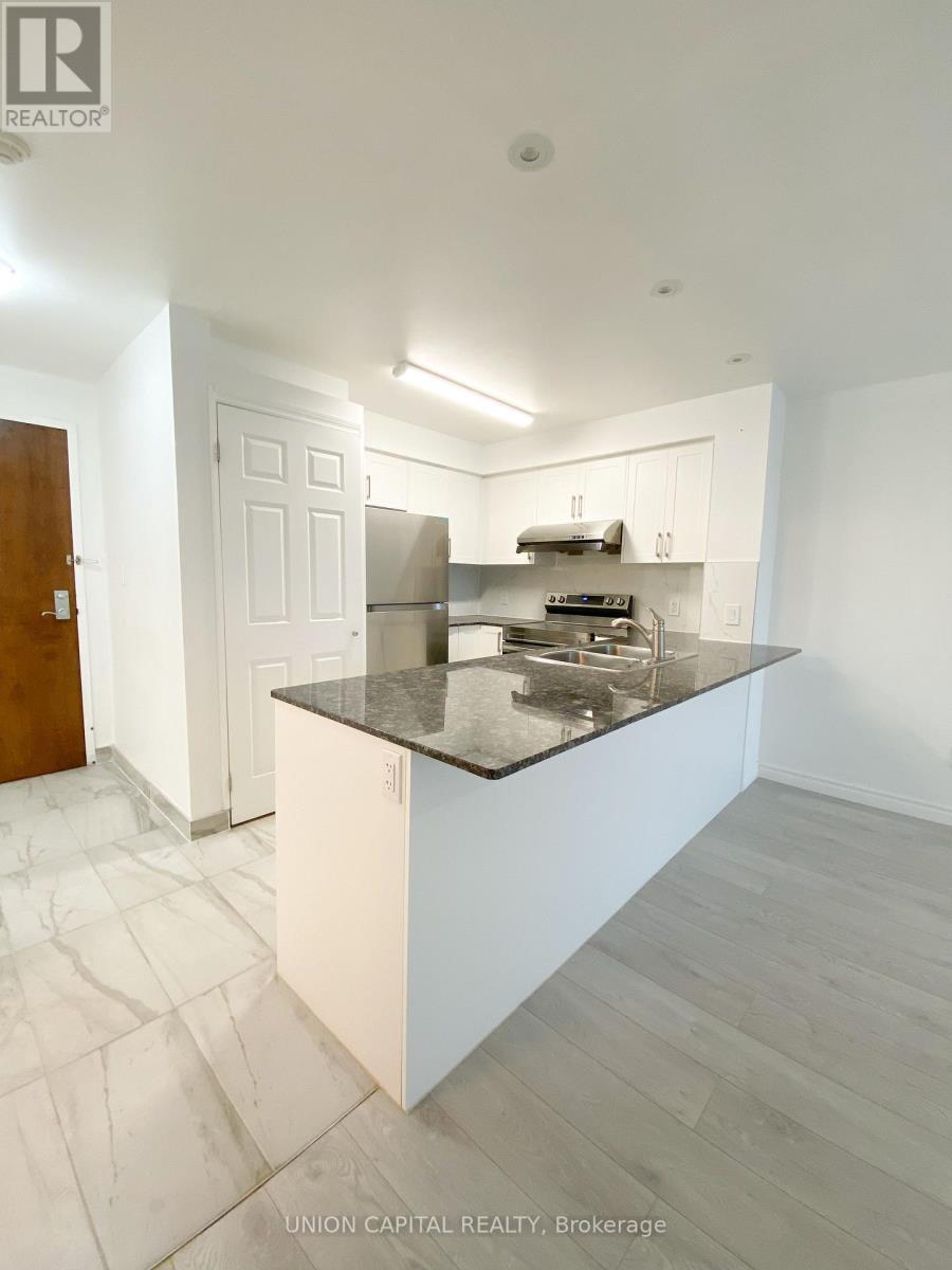 A kitchen with a marble countertop and white cabinets.