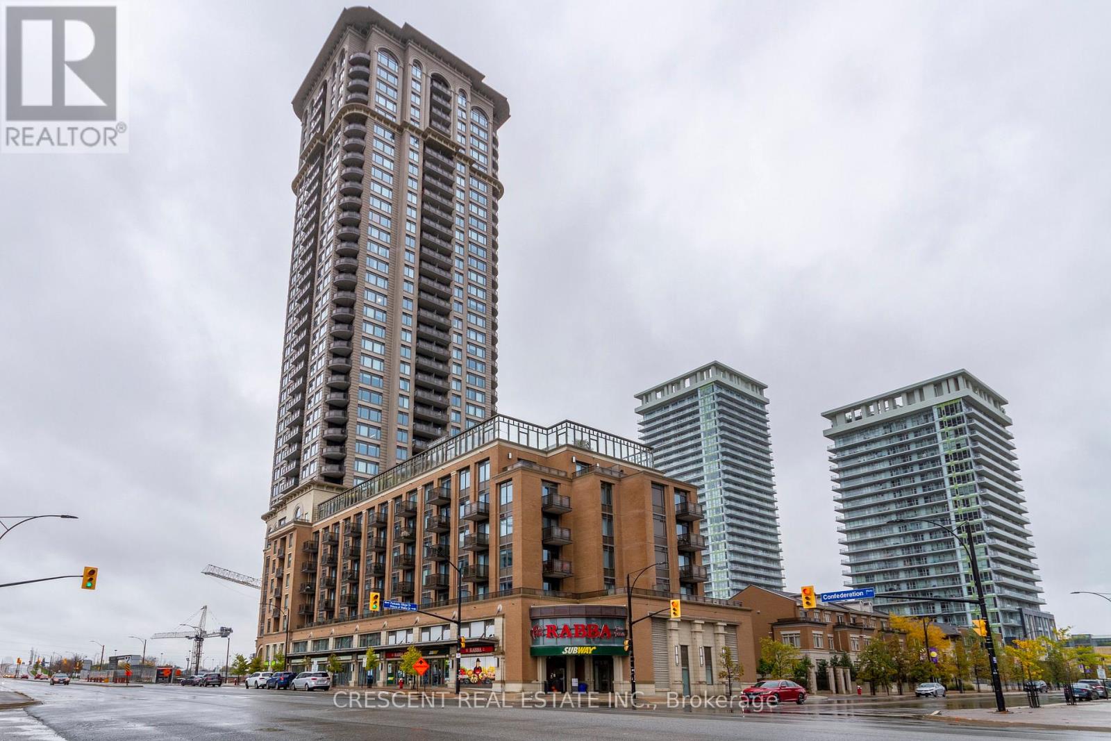 A city street with a large building in the middle and two smaller buildings in the background.